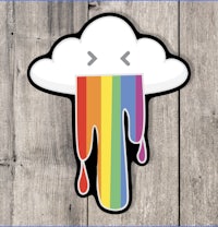 a rainbow dripping cloud sticker on a wooden background