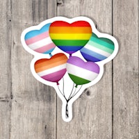 a sticker with rainbow balloons on a wooden background