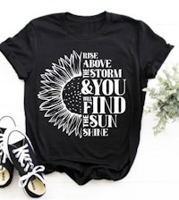 a black t - shirt with a sunflower and a pair of sneakers