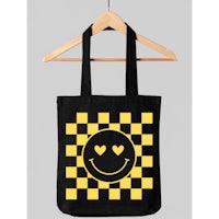 a black and yellow checkered tote bag with a smiley face on it