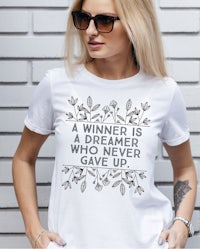 a black shirt that says a winner is a dreamer who never gives up